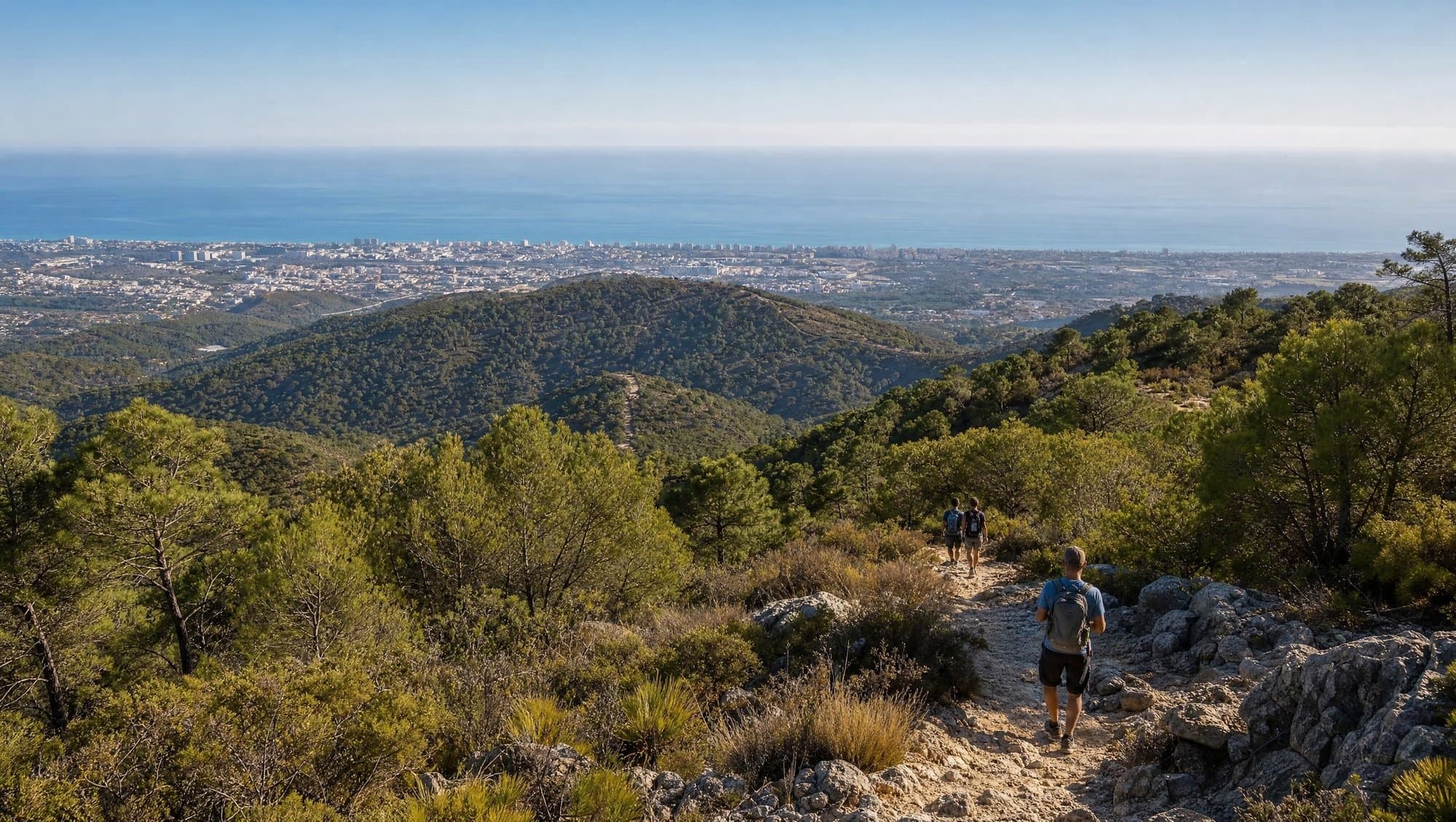 Hikers on a scenic mountain trail above Marbella with Mediterranean sea views