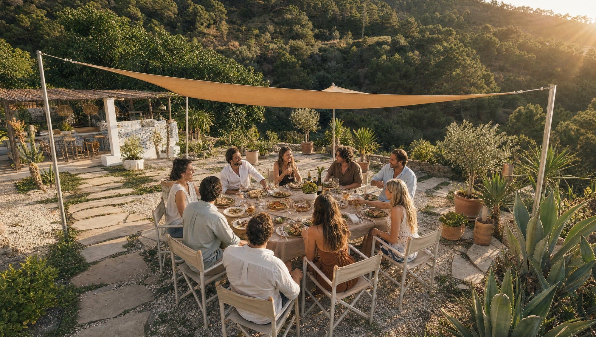 Group of friends gathered around an outdoor table in an Andalusian garden at golden hour